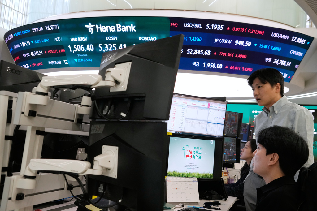 Currency traders watch monitors near a screen showing the Korea Composite Stock Price Index (KOSPI), top center, and the foreign exchange rate between U.S. dollar and South Korean won, top center left, at the foreign exchange dealing room of the Hana Bank headquarters in Seoul, South Korea, Wednesday, April 1, 2026. (AP Photo/Ahn Young-joon)