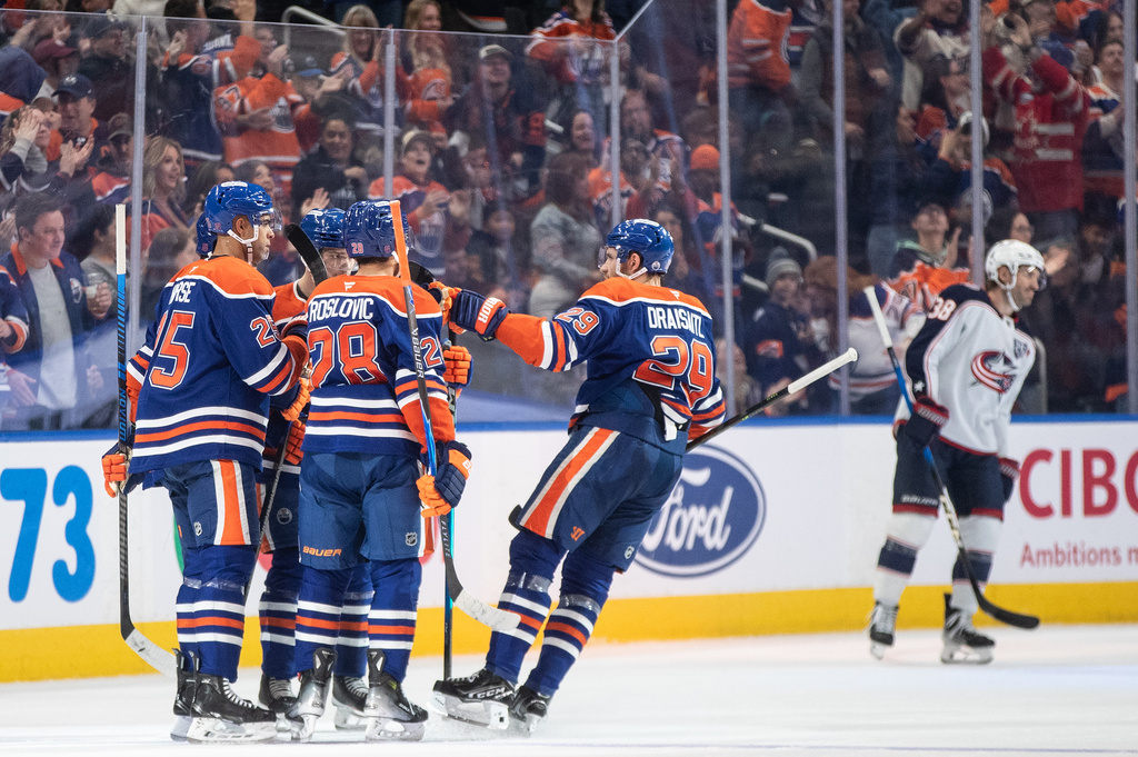 Columbus Blue Jackets' Boone Jenner (38) skates past as the Edmonton Oilers celebrate after a goal during first-period NHL hockey game action in Edmonton, Alberta, Monday, Nov. 10, 2025. (Jason Franson/The Canadian Press via AP)