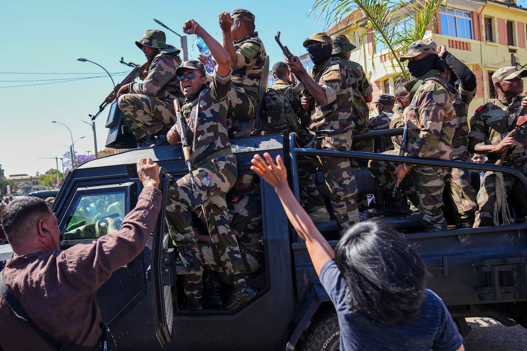 Soldiers are greeted by people gathering for a ceremony in tribute to demonstrators killed during recent anti-government protest in Antananarivo, Madagascar, Sunday, Oct. 12, 2025. (AP Photo/Mamyrael)
