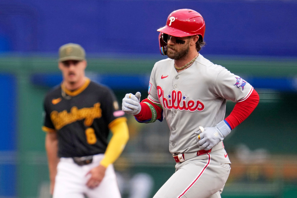Philadelphia Phillies' Bryce Harper, right, rounds the bases past Pittsburgh Pirates shortstop Konnor Griffin, left, after hitting a three-run home run off Pittsburgh Pirates pitcher Bubba Chandler during the first inning of a baseball game in Pittsburgh, Saturday, May 16, 2026. (AP Photo/Gene J. Puskar)