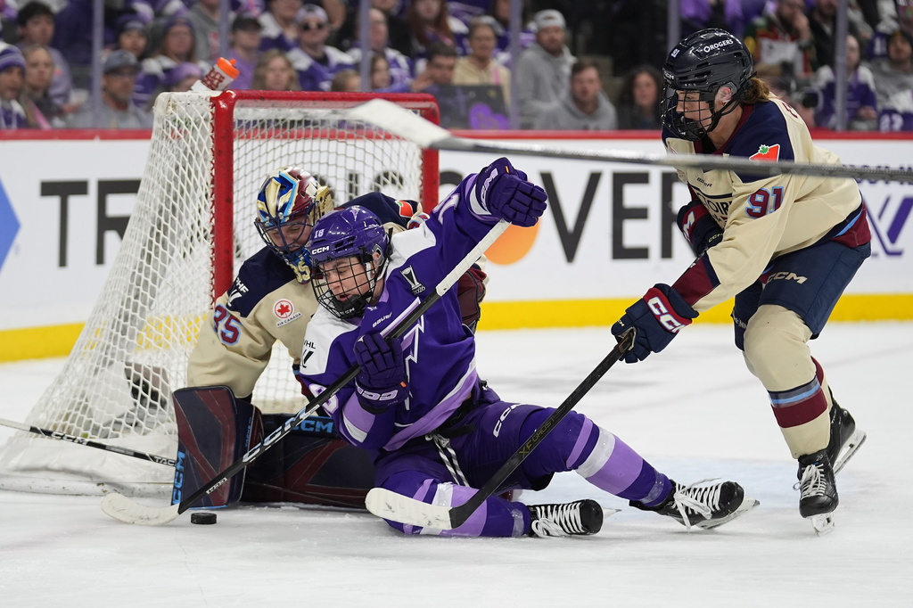 Minnesota Frost forward Élizabeth Giguère (18) reaches for the puck as Montreal Victoire goaltender Ann-Renée Desbiens (35) and Victoire defenseman Maggie Flaherty (91) defend during the third period of game 3 of a PWHL hockey semifinals game, Thursday, May 7, 2026, in St. Paul, Minn. (AP Photo/Abbie Parr)