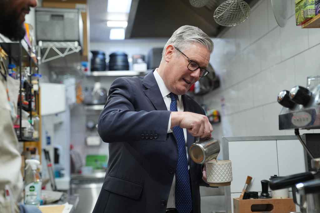 Britain's Prime Minister Keir Starmer pours milk into a cup of tea he made a visit to Home Cafe and Kitchen in London, Monday, May 18, 2026, as new figures have shown the UK recorded stronger than expected economic growth. (Yui Mok/Pool Photo via AP)