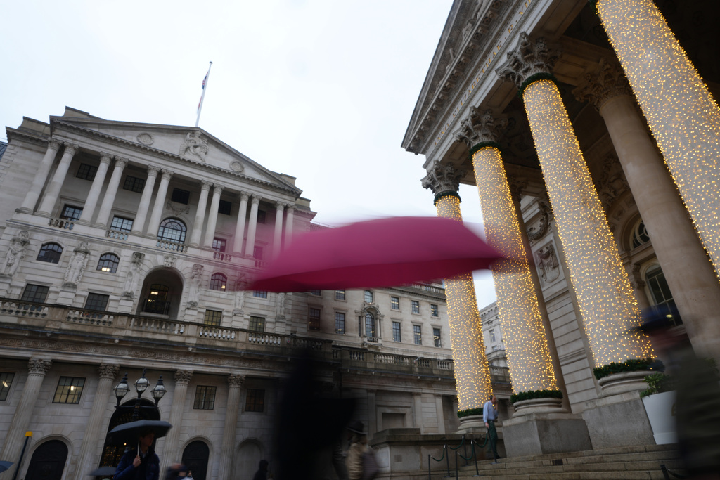 Pedestrians pass the Bank of England in London, as the Monetary Policy Committee (MPC) will publish their decision on interest rates, Thursday, Dec. 18, 2025. (AP Photo/Kirsty Wigglesworth)