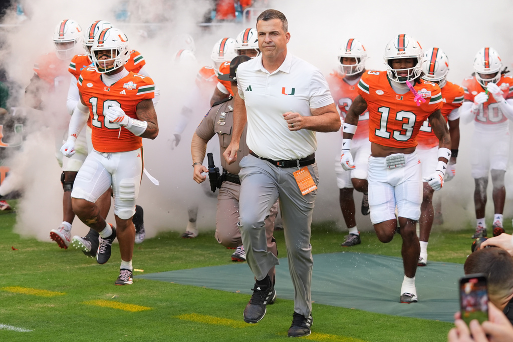 Miami head coach Mario Cristobal enter the field before the first half of an NCAA college football game against Syracuse Saturday, Nov. 8, 2025, in Miami Gardens, Fla. (AP Photo/Marta Lavandier)