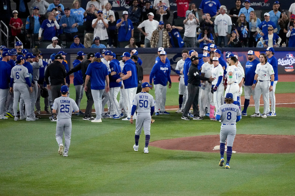 The Los Angeles Dodgers and the Toronto Blue Jays benches clear after Blue Jays' Andrés Giménez was hit by a pitch during the fourth inning in Game 7 of baseball's World Series, Saturday, Nov. 1, 2025, in Toronto. (AP Photo/Ashley Landis)