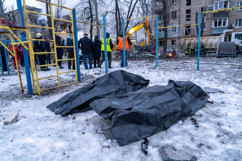 Bodies of local residents lie on the snow in plastic bags near a damaged apartment building following Russia's missile attack in Kharkiv, Ukraine, Saturday, March 7, 2026. (AP Photo/Andrii Marienko)