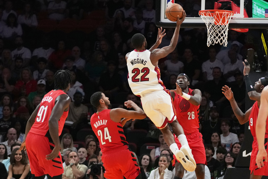 Miami Heat forward Andrew Wiggins (22) goes to the basket as Portland Trail Blazers forward Kris Murray (24) and center Duop Reath (26) defend during the first half of an NBA basketball game, Saturday, Nov. 8, 2025, in Miami. (AP Photo/Lynne Sladky)