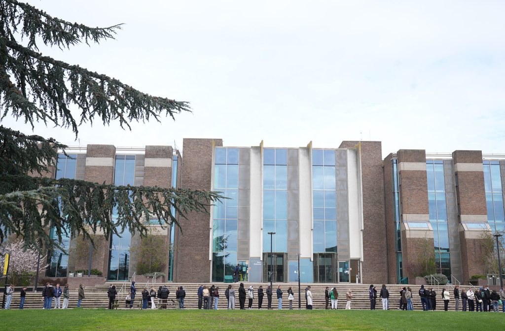 Students queue for antibiotics outside a building at the University of Kent, following an outbreak of meningitis, in Canterbury, Kent, England, Monday March 16, 2026. (Gareth Fuller/PA via AP)