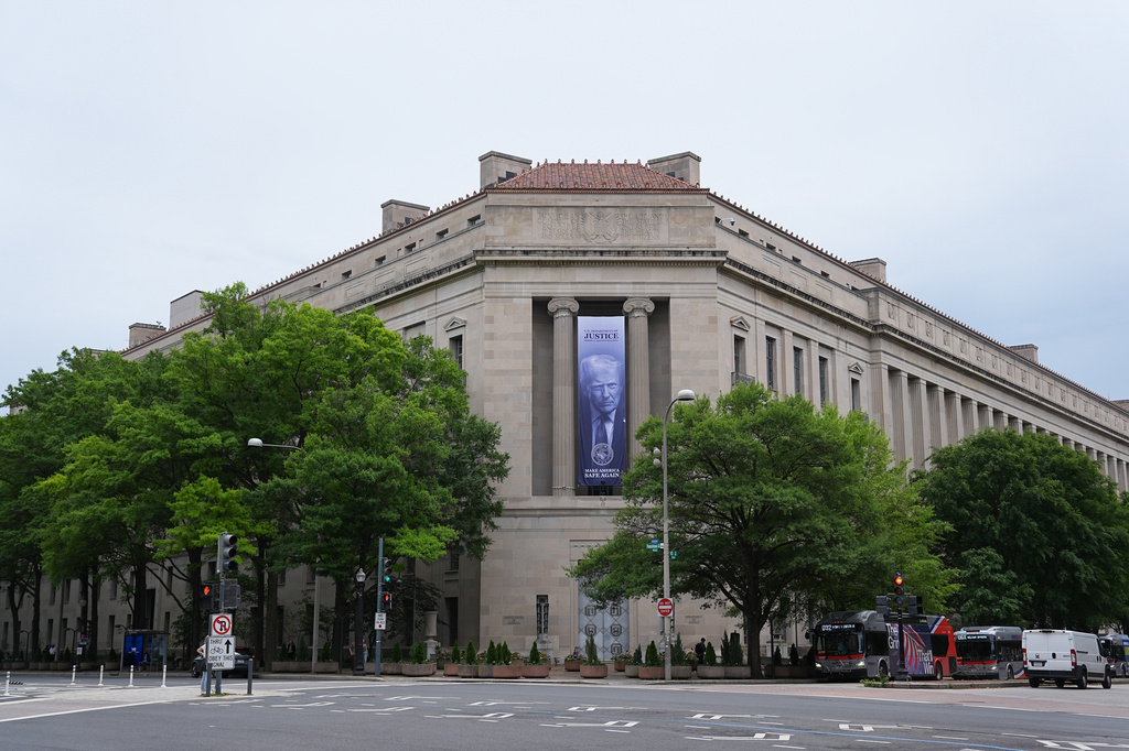 FILE - A banner featuring an image of President Donald Trump hangs on the Department of Justice in Washington, Wednesday, May 27, 2026. (AP Photo/Matt Rourke)