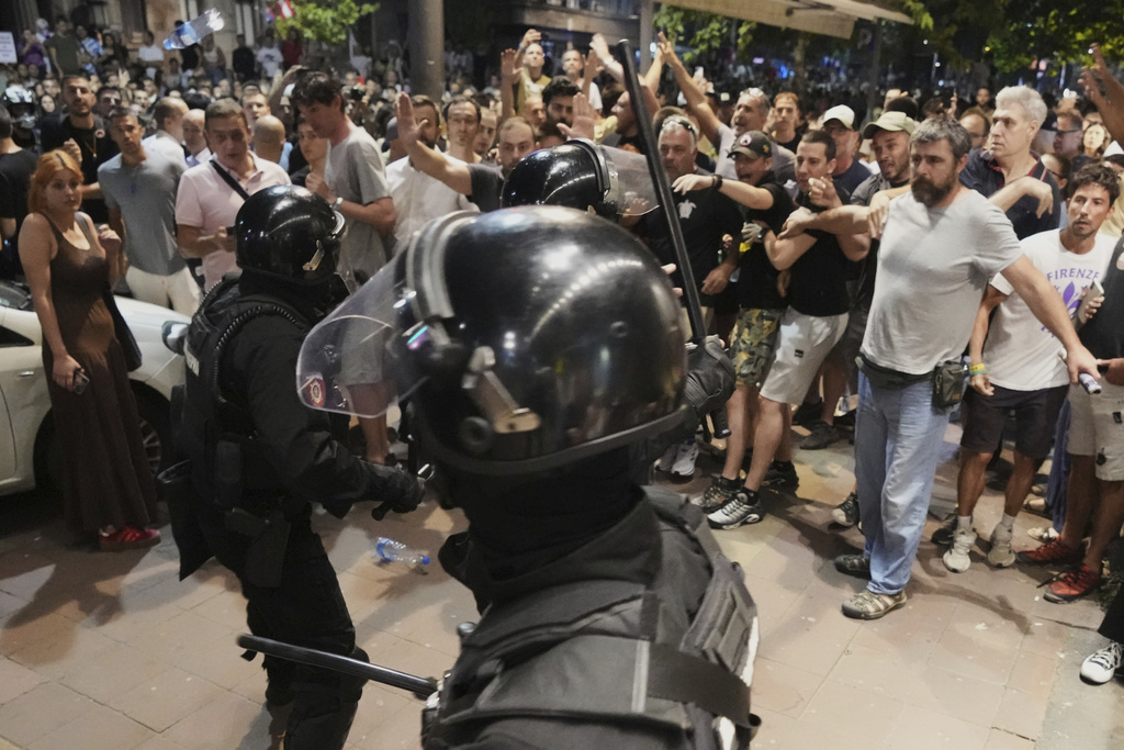 Serbian gendarmerie officers separate protesters from opposing camps during an anti-government protest in Belgrade, Serbia, Wednesday, Aug. 13, 2025. (AP Photo/Darko Vojinovic)