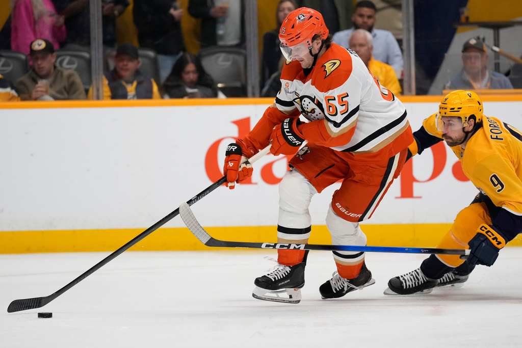 Anaheim Ducks defenseman Jacob Trouba (65) moves the puck past Nashville Predators left wing Filip Forsberg (9) during the second period of an NHL hockey game Tuesday, Oct. 21, 2025, in Nashville, Tenn. (AP Photo/George Walker IV)