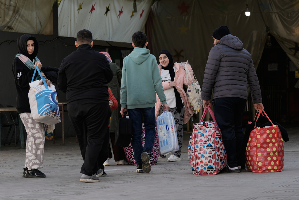 Displaced families fleeing Israeli airstrikes in southern Lebanon arrive at a school turned into a shelter, in Beirut, Lebanon, Monday, March 2, 2026. (AP Photo/Bilal Hussein)