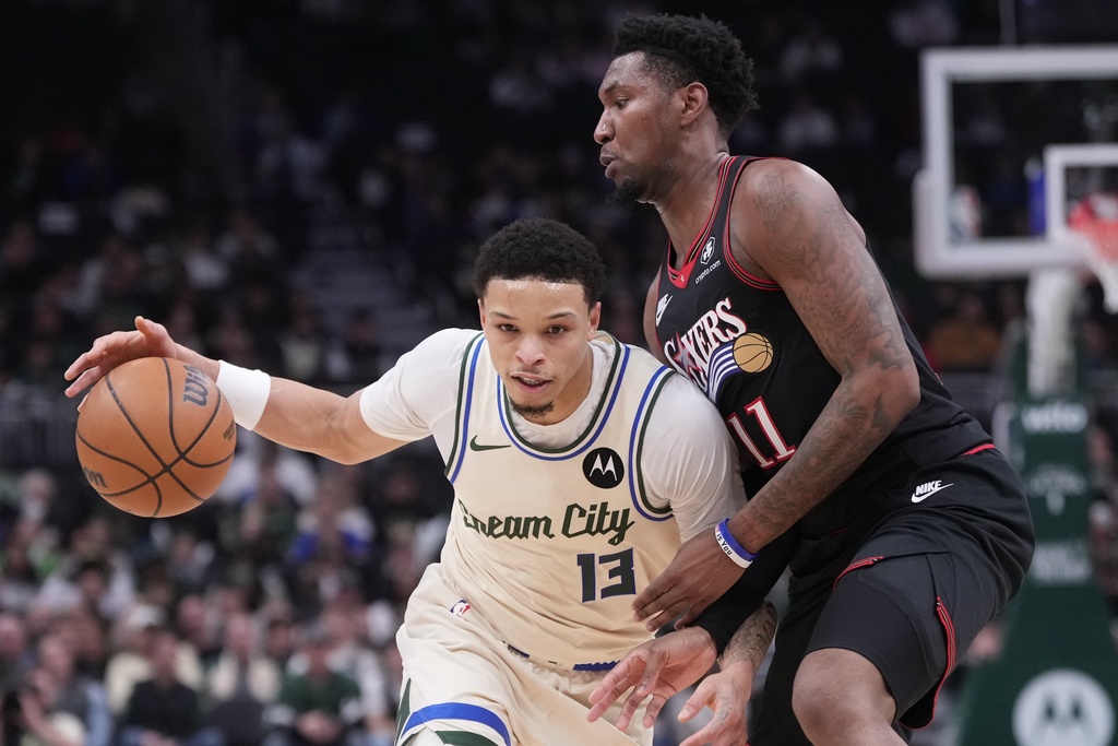 Milwaukee Bucks' Ryan Rollins tries to get past Philadelphia 76ers' Justin Edwards during the first half of an NBA basketball game Thursday, Nov. 20, 2025, in Milwaukee. (AP Photo/Morry Gash)