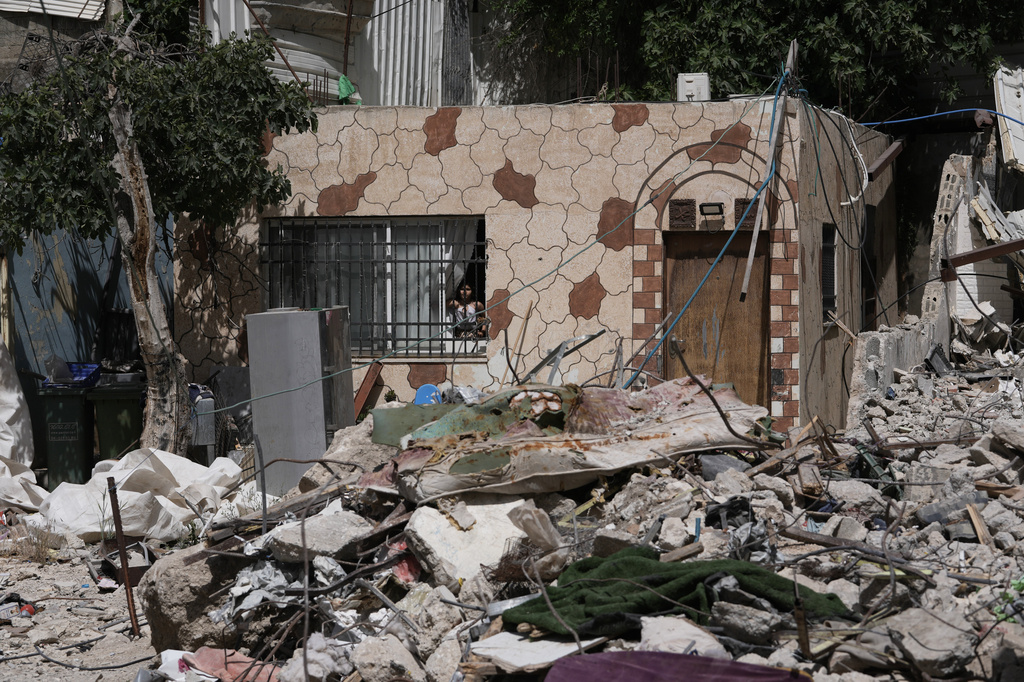 A Palestinian girl looks out a window at the rubble of a home demolished by Israeli authorities in the Silwan neighborhood of east Jerusalem, May 19, 2026. (AP Photo/Mahmoud Illean)