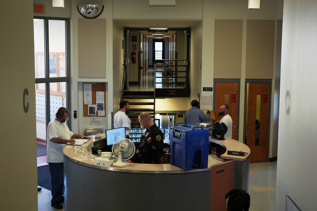 People who are incarcerated roam near the security desk, which is equipped with a fan and water cooler, at a Minnesota Correctional Facility in Lino Lakes, Minn., Tuesday, Sept. 15, 2026. (AP Photo/Ellen Schmidt)
