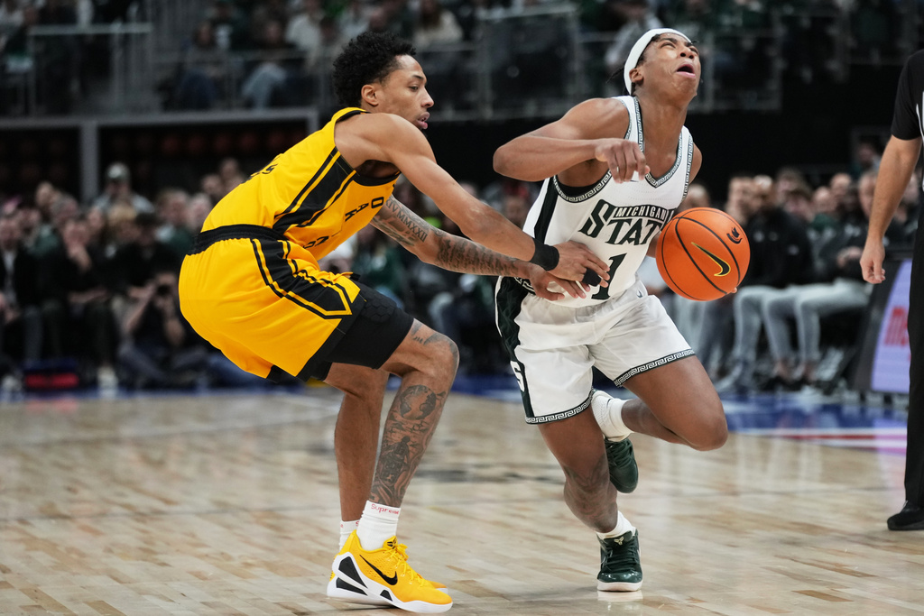Michigan State guard Jeremy Fears Jr., right, is defended by Oakland guard Ziare Wells during the first half of an NCAA college basketball game, Saturday, Dec. 20, 2025, in Detroit. (AP Photo/Ryan Sun)
