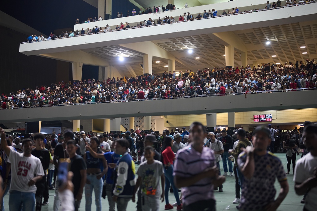 Spectators watch horse races during the 56th Jockey Challenge at the Rinconada racetrack in Caracas, Venezuela, Sunday, Dec. 14, 2025. (AP Photo/Arian Cubillos)