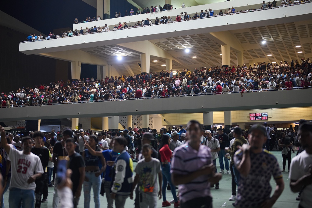 Spectators watch horse races during the 56th Jockey Challenge at the Rinconada racetrack in Caracas, Venezuela, Sunday, Dec. 14, 2025. (AP Photo/Ariana Cubillos)