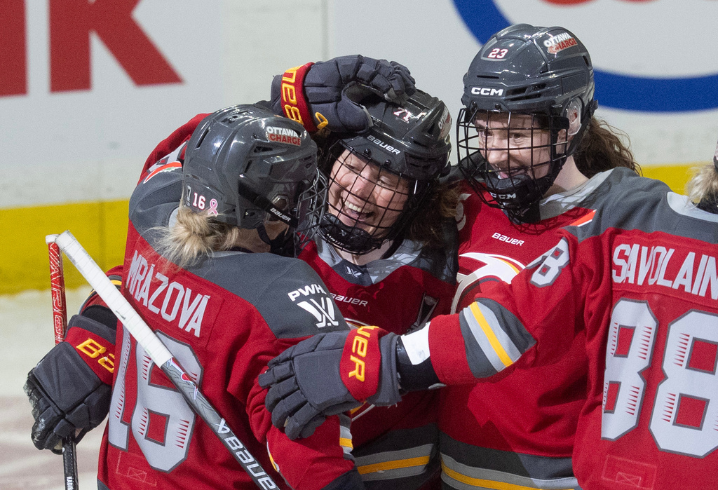 Ottawa Charge forward Fanuza Kadirova (71) celebrates after her goal with forwards Katerina Mrazova (16) and Sarah Wozniewicz (23) during the first period of Game 4 in a PWHL hockey playoff series against the Bosotn Fleet in Ottawa, Ontario, Sunday, May 10, 2026. (Adrian Wyld/The Canadian Press via AP)