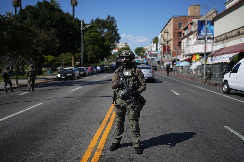 A law enforcement officer stands on a street near MacArthur Park after federal authorities made arrests on charges related to selling illicit drugs on Wednesday, May 6, 2026, in Los Angeles. (AP Photo/Jae C. Hong)