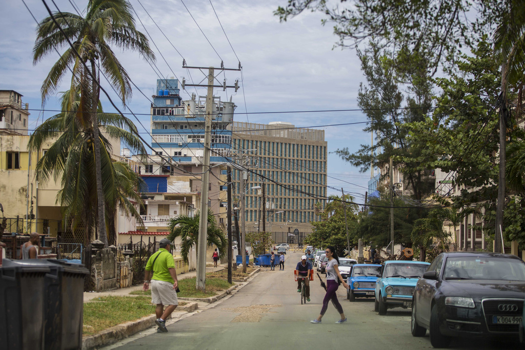 FILE - Pedestrians walk on a street that leads to the United States Embassy, center in background, in Havana, Cuba, Sept. 27, 2017. (AP Photo/Desmond Boylan, File)