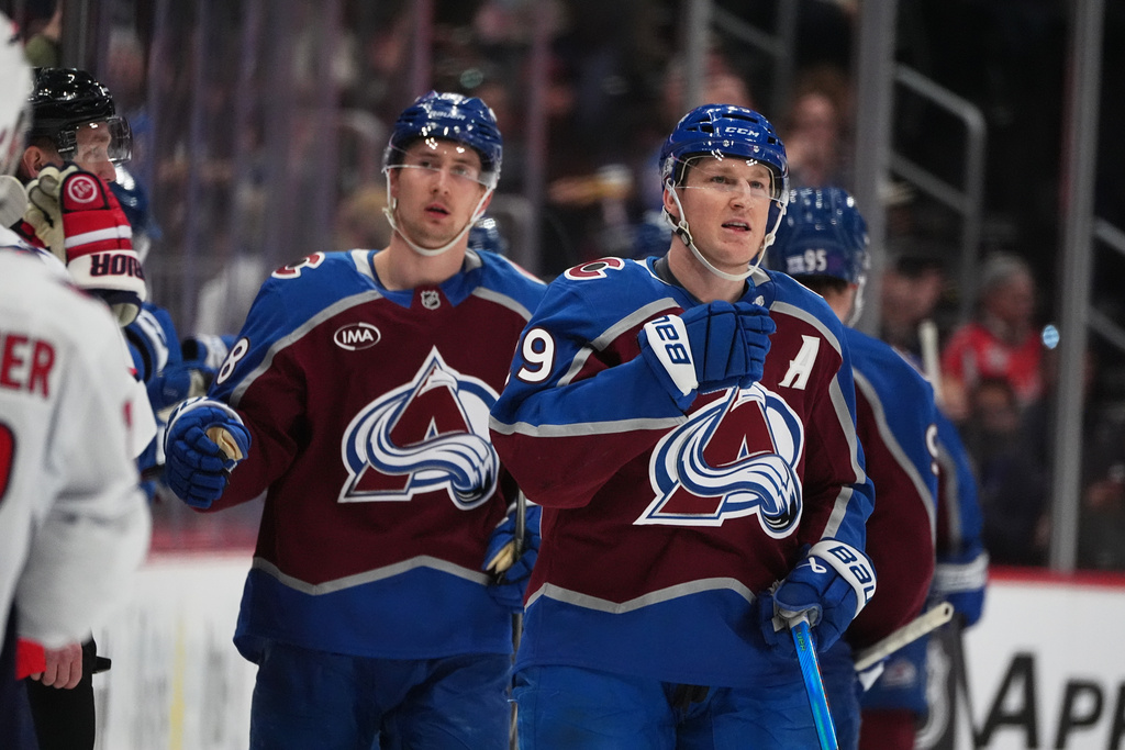 Colorado Avalanche center Nathan MacKinnon, right, reacts after scoring as center Martin Necas, left, follows in the second period of an NHL hockey game against the Washington Capitals, Monday, Jan. 19, 2026, in Denver. (AP Photo/David Zalubowski)