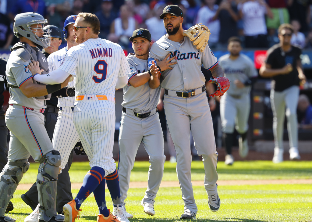 Miami Marlins' Javier Sanoja, second from right, restrains pitcher Sandy Alcantara, right, as the benches emptied after Alcantara hit New York Mets' Mark Vientos with a throw during the seventh inning of a baseball game, Sunday, Aug. 31, 2025, in New York. (AP Photo/Noah K. Murray)