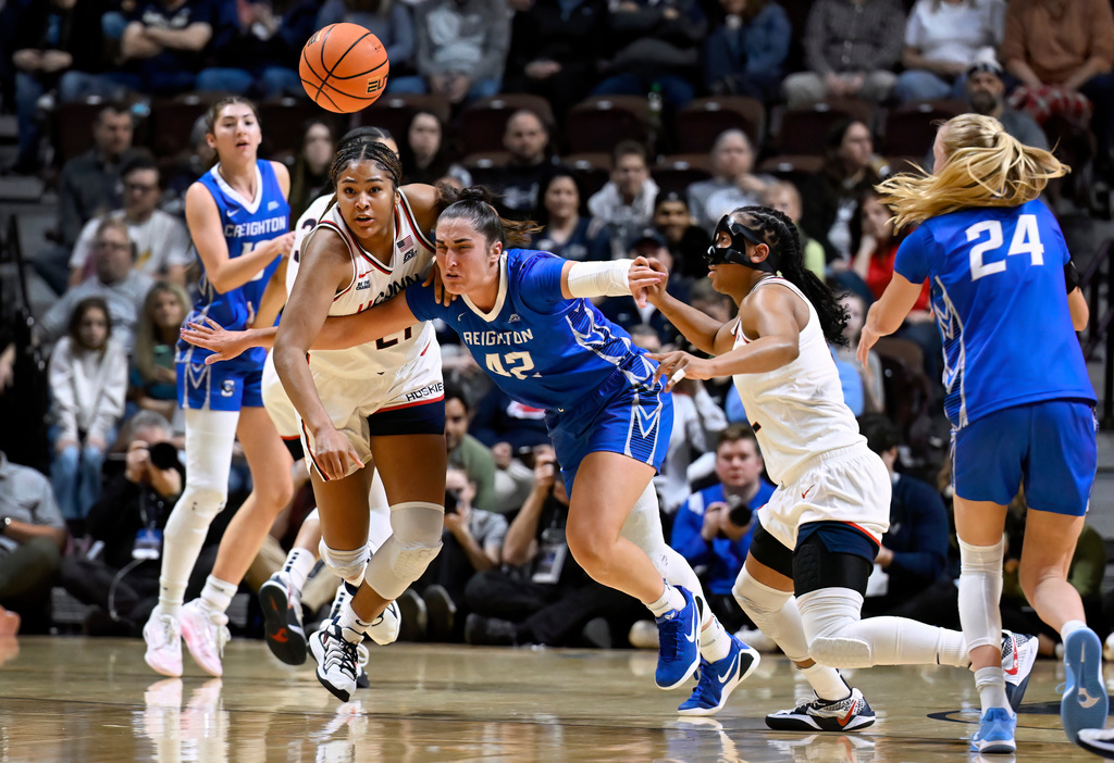 Creighton forward Grace Boffeli, center, looses the ball under pressure from UConn forward Sarah Strong, left, and UConn guard KK Arnold, right, during first half of an NCAA college basketball game in the semifinals of the Big East tournament, Sunday, March 8, 2026, in Uncasville, Conn. (AP Photo/Jessica Hill)