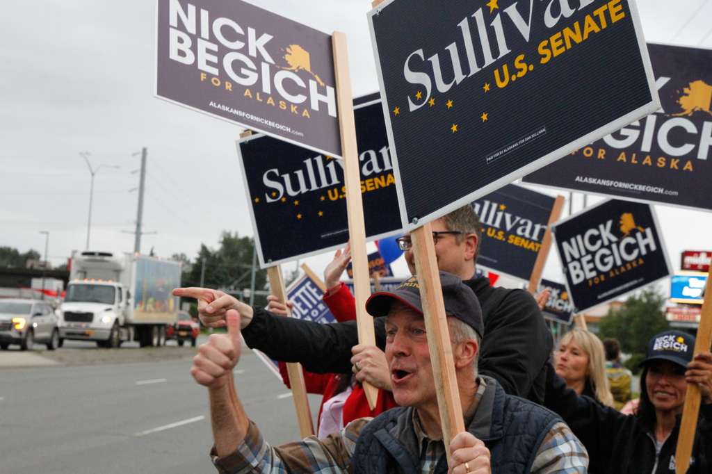 Sen. Dan Sullivan, R-Alaska, who is seeking a third term, flashes a thumbs up after a passing motorist honked during a sign waving event at an intersection on primary election day in Anchorage, Alaska, Tuesday, Aug. 18, 2026. (AP Photo/Mark Thiessen)