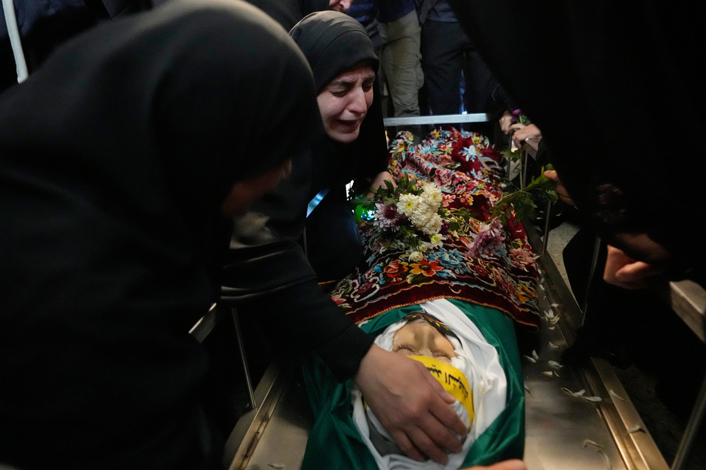 FILE — Malak Meslmani, center, the mother of Jawad Younes, 11, who was was killed in an Israeli airstrike, mourns over her son's body during his funeral procession in Saksakieh village, south Lebanon, Saturday, March 28, 2026. (AP Photo/Hussein Malla, File)