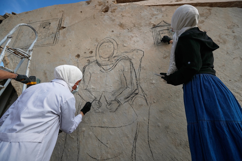A group of Syrian graffiti artists paint a mural on the collapsed ceiling of a war-damaged house in Daraya, on the outskirts of Damascus, Syria, Monday, Nov. 3, 2025. (AP Photo/Omar Sanadiki)
