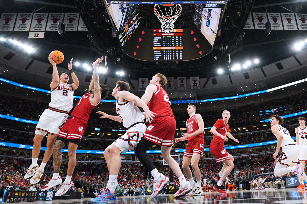 Illinois guard Andrej Stojakovic, left, shoots over Wisconsin guard Braeden Carrington during the first half of an NCAA college basketball game in the quarterfinals of the Big 10 Conference tournament, Friday, March 13, 2026, in Chicago. (AP Photo/Nam Y. Huh)