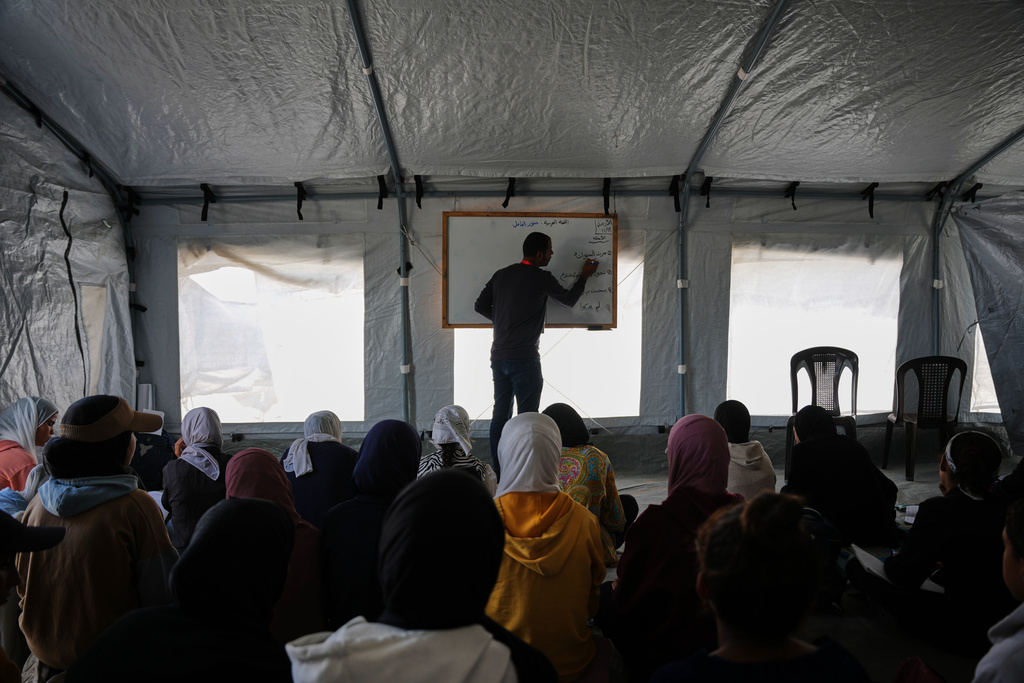 Palestinian students attend class inside a tent set up on the beach in Khan Younis, Gaza Strip, Wednesday, Nov. 12, 2025. (AP Photo/Abdel Kareem Hana)
