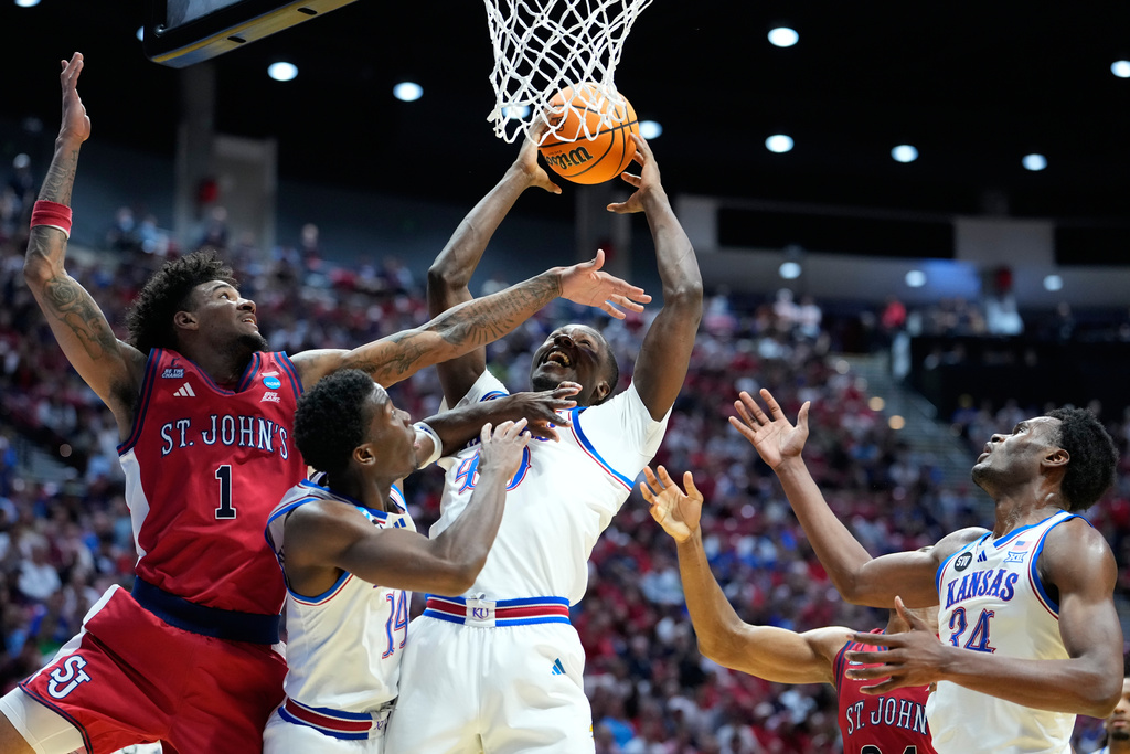 From left, St. John's forward Dillon Mitchell (1), Kansas guard Melvin Council Jr. (14), Kansas forward Flory Bidunga (40) and Kansas center Paul Mbiya (34) battle for a rebound during the first half of a game in the second round of the NCAA college basketball tournament Sunday, March 22, 2026, in San Diego. (AP Photo/Mark J. Terrill)