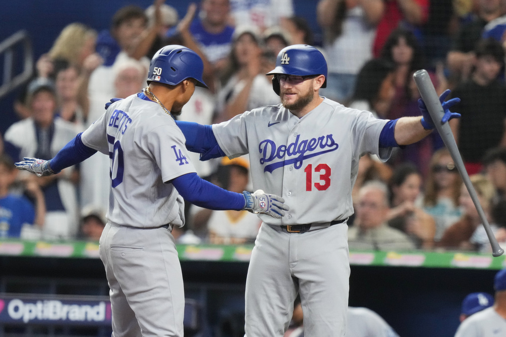 Los Angeles Dodgers' Mookie Betts (50) is met by Max Muncy (13) after hitting also home run during the first inning of a baseball game against the Miami Marlins, Saturday, Sept. 12, 2026, in Miami. (AP Photo/Lynne Sladky)
