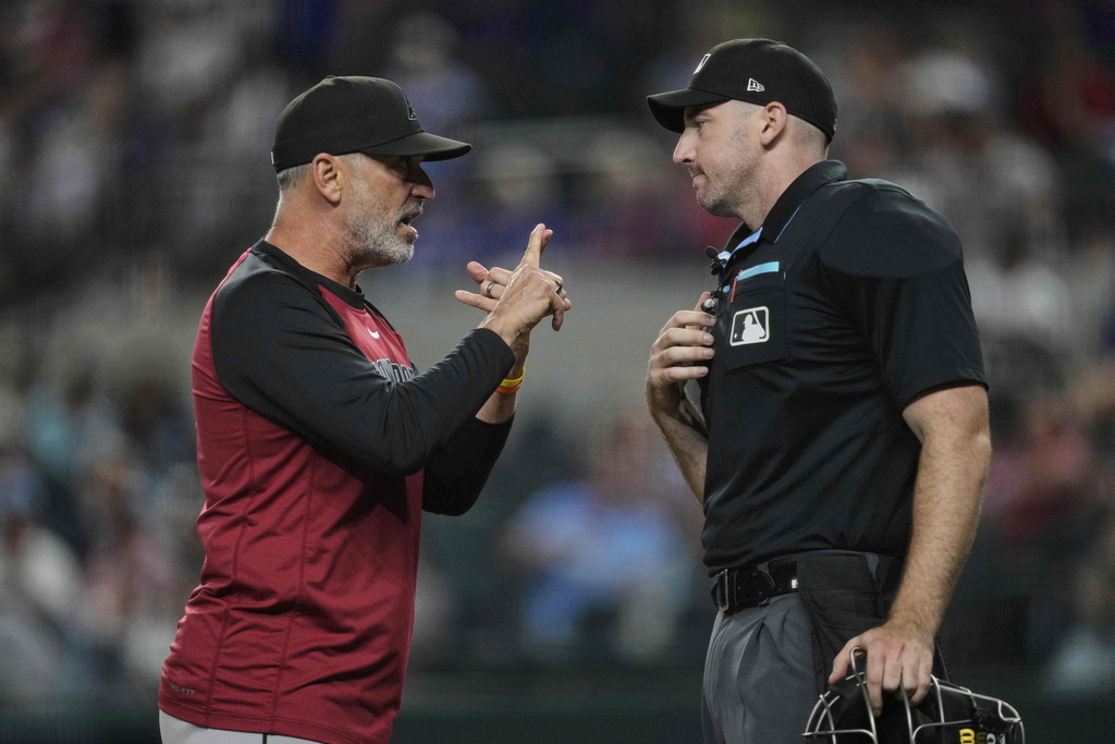 Arizona Diamondbacks manager Torey Lovullo, left, argues with home plate umpire Nate Tomlinson after Lovullo was ejected in the ninth inning of a baseball game against the Texas Rangers Tuesday, Aug. 12, 2025, in Arlington, Texas. (AP Photo/Tony Gutierrez)