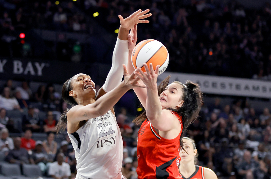 Las Vegas Aces center A'ja Wilson (22) and Portland Fire center Megan DiLeo fight for the ball during the first half of an WNBA basketball game Tuesday, July 28, 2026, in Las Vegas. (Steve Marcus/Las Vegas Sun via AP)