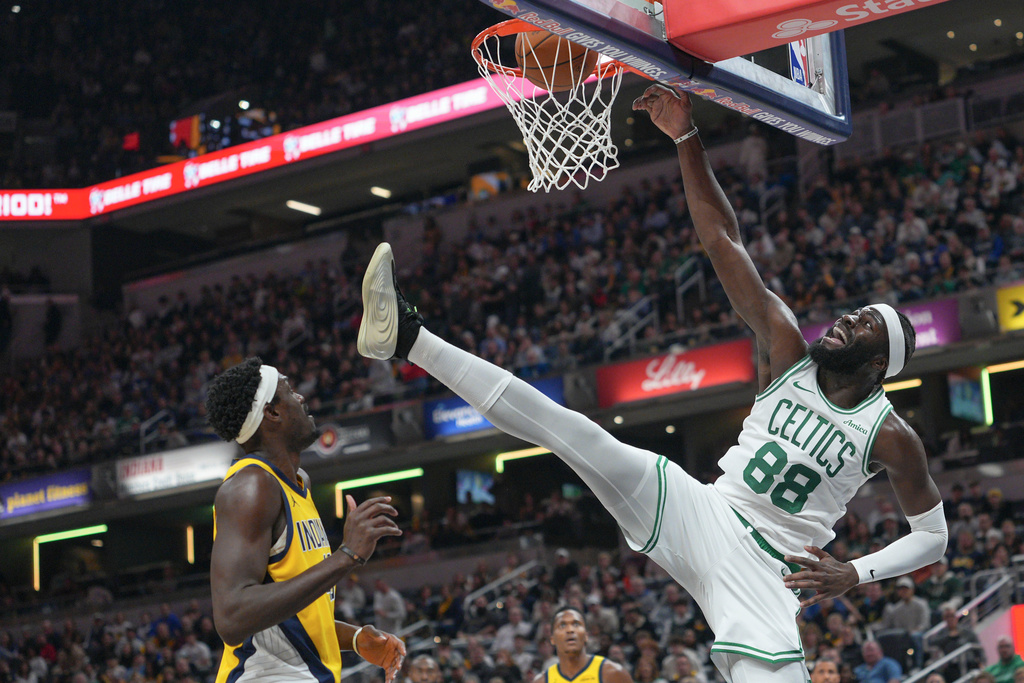 Boston Celtics center Neemias Queta, right, dunks in front of Indiana Pacers forward Pascal Siakam, left, during the first half of an NBA basketball game in Indianapolis, Friday, Dec. 26, 2025. (AP Photo/AJ Mast)