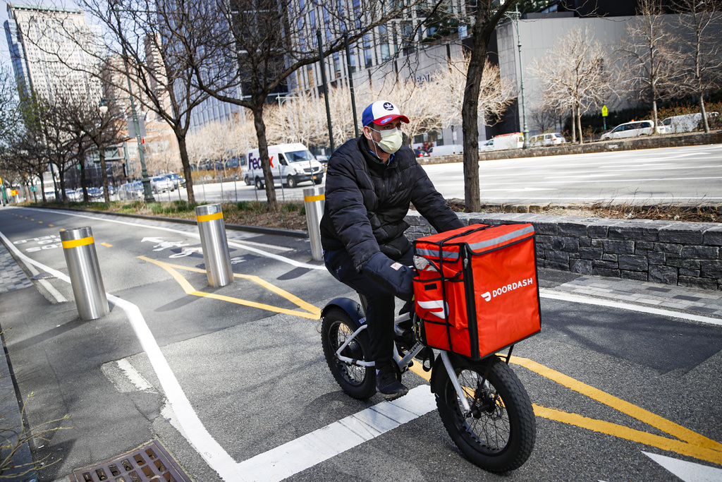 FILE - A delivery worker rides his bicycle along a path on the West Side Highway in New York, March 16, 2020. (AP Photo/John Minchillo, File)