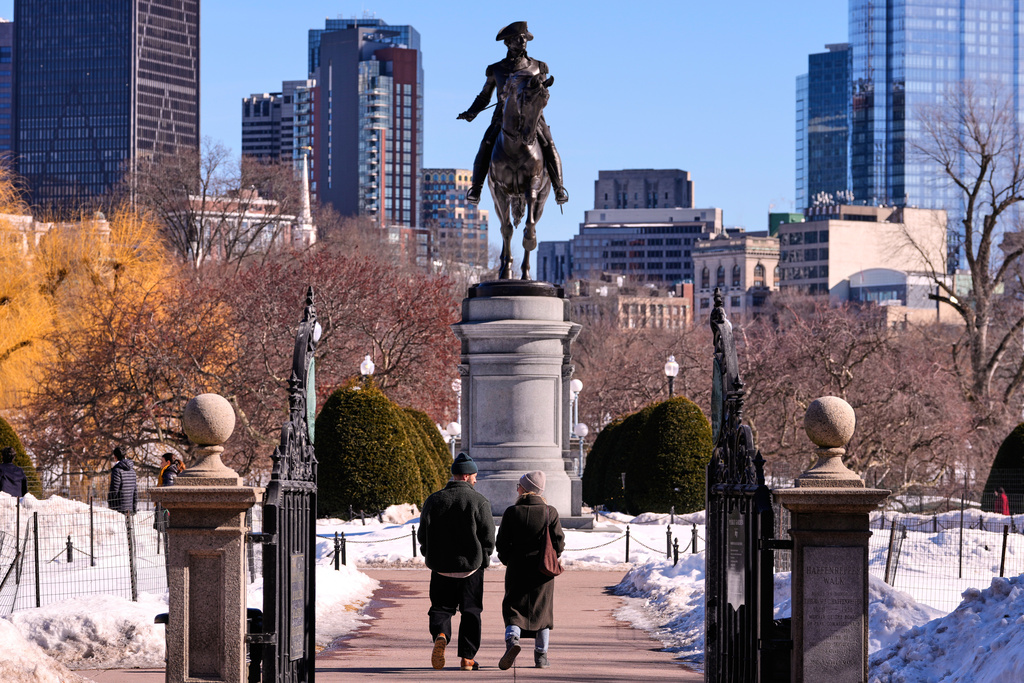 A couple walks toward a statue of George Washington on horseback at the Public Garden, Friday, Feb. 13, 2026, in Boston. (AP Photo/Charles Krupa)