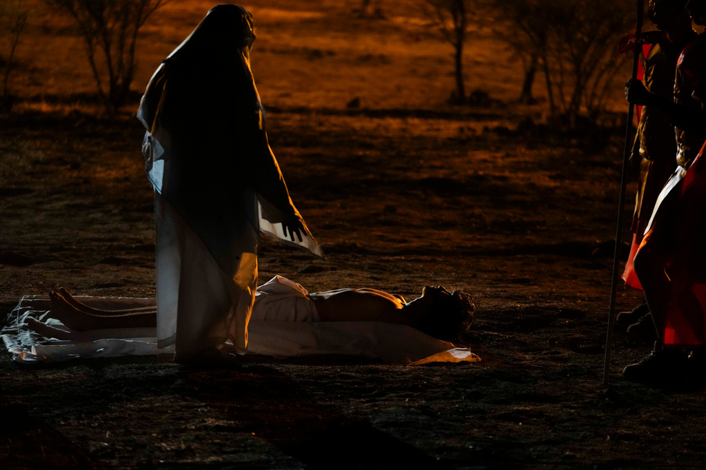 A woman playing the role of Mary stands before David Sanchez, playing the role of Jesus Christ, after he was taken down from the cross during a Way of the Cross reenactment as part of Holy Week celebrations, in Colina, Chile, on Good Friday, April 3, 2026. (AP Photo/Esteban Felix)