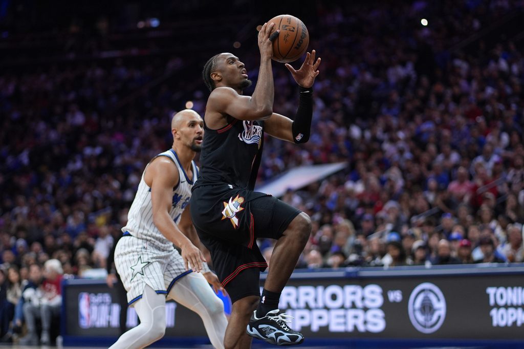 Philadelphia 76ers' Tyrese Maxey, right, goes up for a shot against Orlando Magic's Jalen Suggs during the second half of an NBA play-in tournament basketball game Wednesday, April 15, 2026, in Philadelphia. (AP Photo/Matt Slocum)