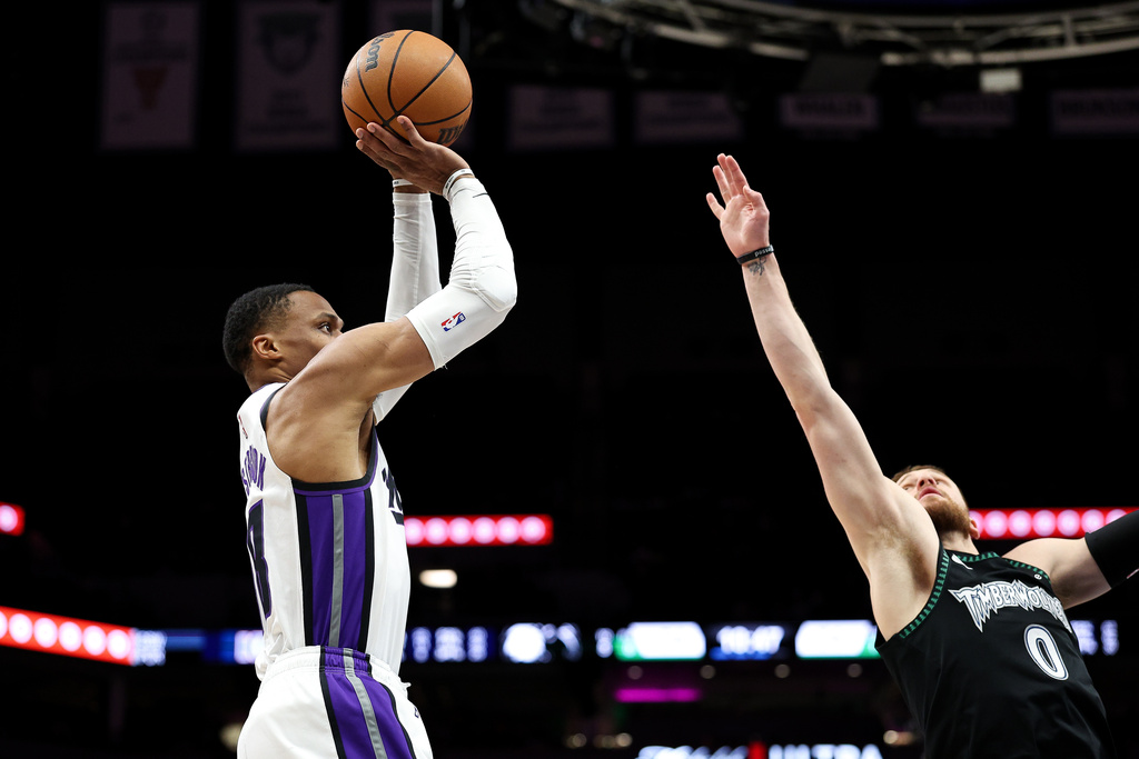 Sacramento Kings guard Russell Westbrook, left, looks to shoot as Minnesota Timberwolves guard Donte Divincenzo (0) defends during the second half of an NBA basketball game Sunday, Dec. 14, 2025, in Minneapolis. (AP Photo/Matt Krohn)