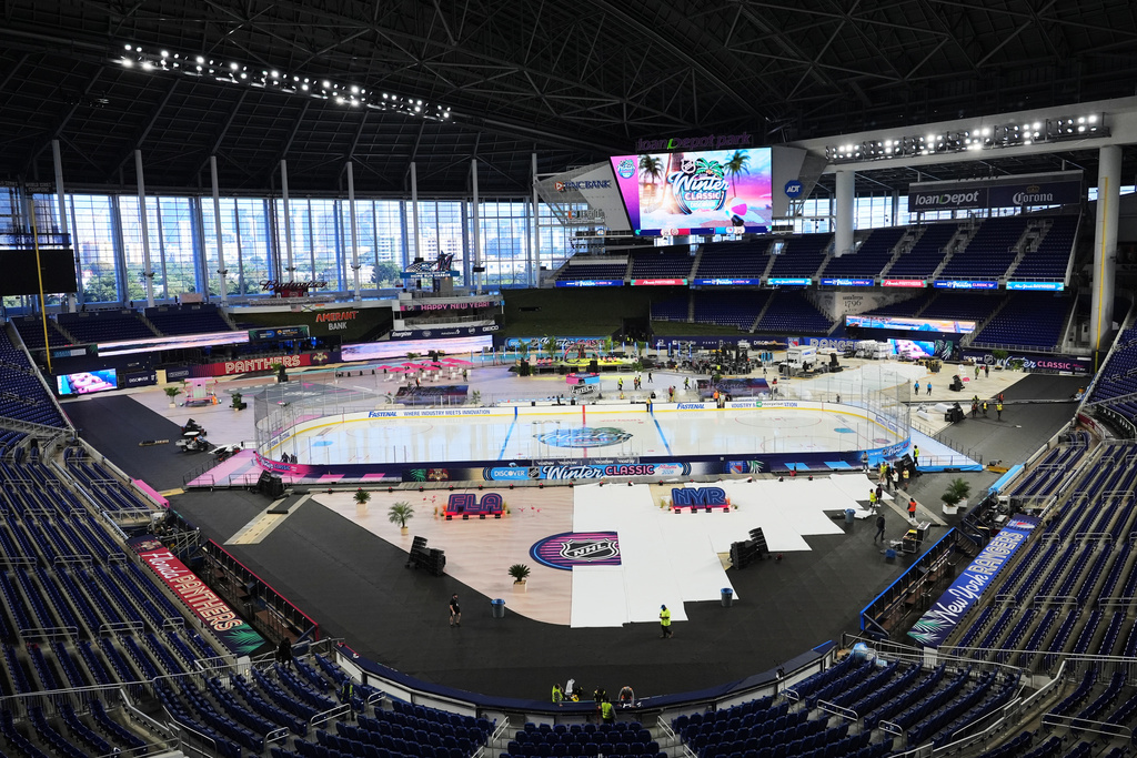 Workers prepare the ice for the upcoming NHL Winter Classic hockey game between the Florida Panthers and New York Rangers, Tuesday, Dec. 30, 2025, at loanDepot Park in Miami. (AP Photo/Lynne Sladky)