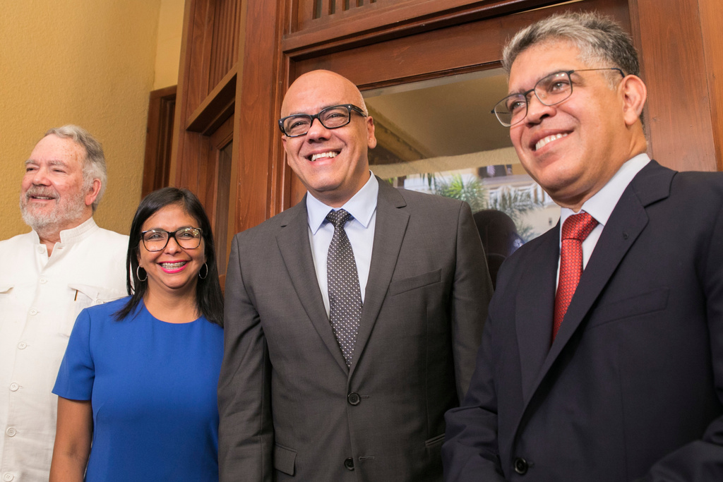 FILE - Constitutional Assembly President Delcy Rodriguez, and her brother, Minister of Communications Jorge Rodriguez, center right, flanked by diplomat Roy Chaderton, left, and former Vice President Elias Jaua, pose for a photo at the Ministry of Foreign Affairs in Santo Domingo, Dominican Republic, Dec. 1, 2017. (AP Photo/Tatiana Fernandez, File)
