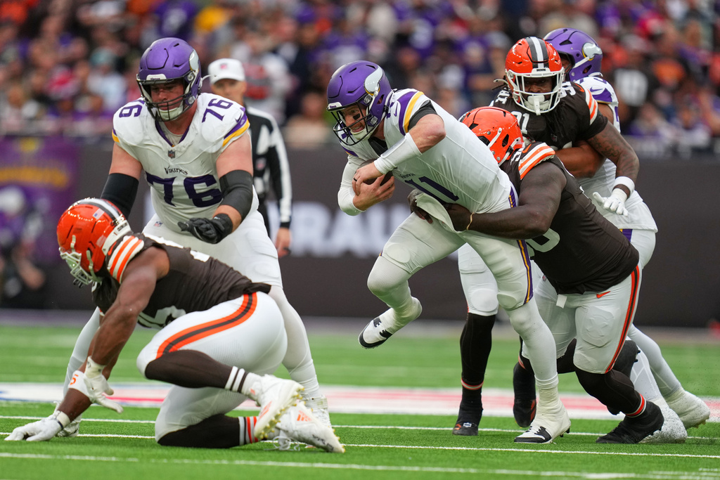 Minnesota Vikings quarterback Carson Wentz (11) is tackled during the second half of the NFL game between Minnesota Vikings and Cleveland Browns at the Tottenham Hotspur stadium in London, Sunday, Oct. 5, 2025. (AP Photo/Kirsty Wigglesworth)