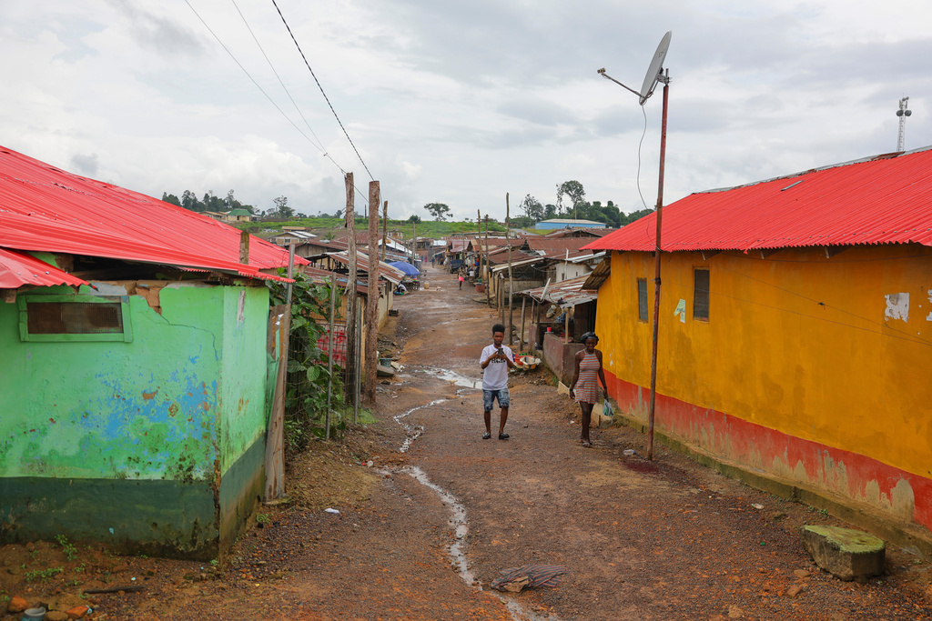 People walk on through Kinjor, Liberia, on July 8, 2025. (AP Photo/Misper Apawu)