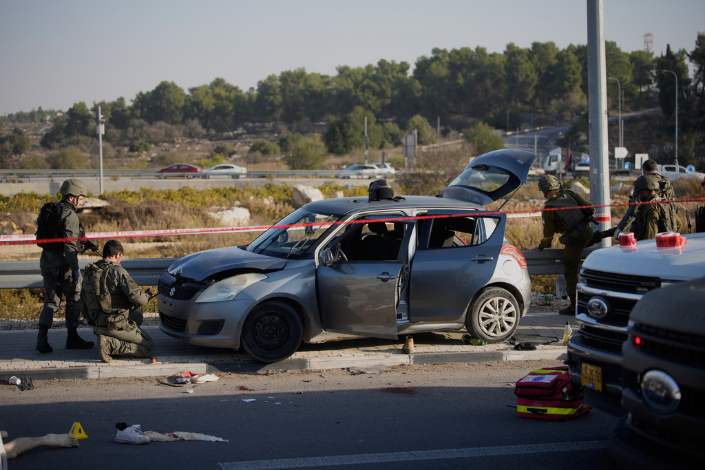 Members of Israeli security forces inspect the site of a ramming and stabbing attack near the West Bank Jewish settlement of Gush Etzion, Tuesday, Nov. 18, 2025. (AP Photo/Ohad Zwigenberg)