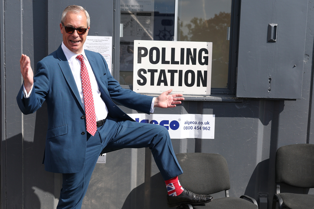 Britain's Reform Party leader Nigel Farage shows his socks as he arrives at a polling station in Walton on the Naze, England, Thursday, May 7, 2026 to cast his vote in the local elections.(AP Photo/Richard Pelham)