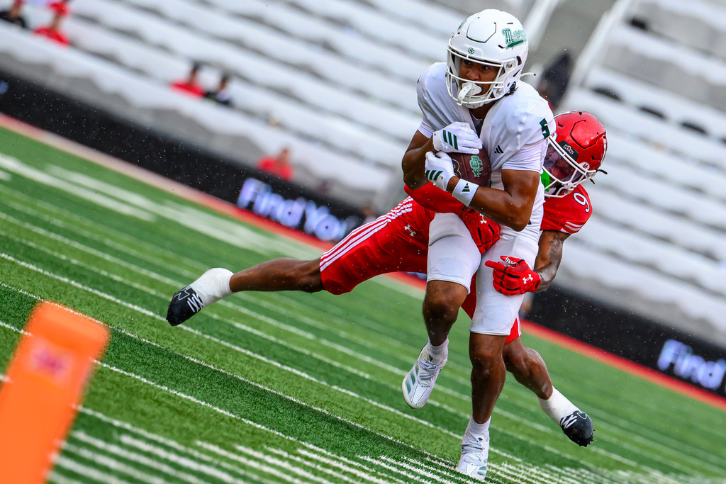 Cal Poly wide receiver Jordan Garrison (5) makes the catch and is tackled by Utah cornerback Elijah Davis (9) during an NCAA college football game Saturday, Sept. 6, 2025, in Salt Lake City, Utah. (AP Photo/Tyler Tate)